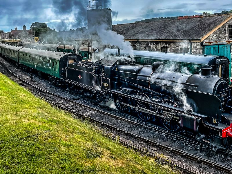 steam train travelling through village station by nick fewings unsplash